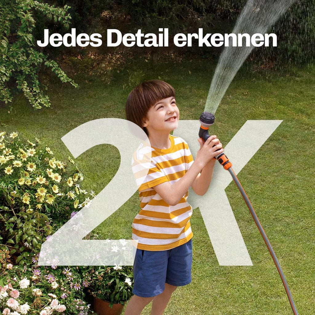 Junge spielt mit Wasserschlauch im Garten, aufgenommen in gestochen scharfer 2K-Auflösung